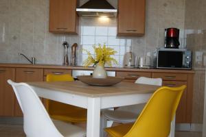 a kitchen with a table and yellow chairs at Vue sur mer à Santa Severa - Appartement Les Cyprès in Marine de Luri