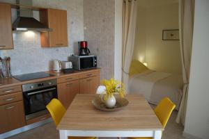 a small kitchen with a table with yellow chairs at Vue sur mer à Santa Severa - Appartement Les Cyprès in Marine de Luri