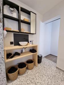 a bathroom with a shelf with a sink and baskets at Le 39 bis in Jalhay