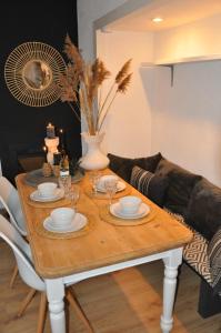 una mesa de madera con platos y gafas en la sala de estar. en Sunny Reef, en Egmond aan Zee