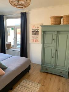 a bedroom with a bed and a green cabinet at Sunny Reef in Egmond aan Zee