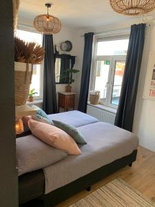 een slaapkamer met 2 bedden met kussens en een raam bij Sunny Reef in Egmond aan Zee