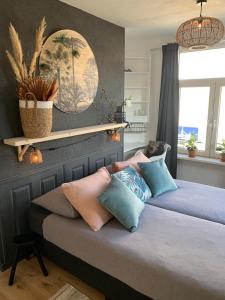 una camera da letto con un letto con cuscini sopra di Sunny Reef a Egmond aan Zee