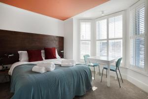 a bedroom with a bed with a table and chairs at Stylish Eco-Friendly Apartments in Folkestone in Folkestone