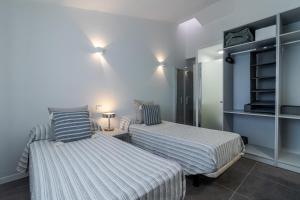 a bedroom with two beds and a room with shelves at Beach Luxury Bungalow in San Bartolomé de Tirajana