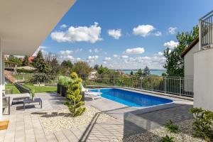 a house with a swimming pool and a patio at Lake Spirit Boutique Apartments in Balatonalmádi