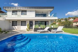 a house with a swimming pool in front of a house at Lake Spirit Boutique Apartments in Balatonalmádi