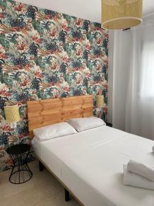 um quarto com uma cama grande e papel de parede floral em Charlot Center Apartment I em Alicante