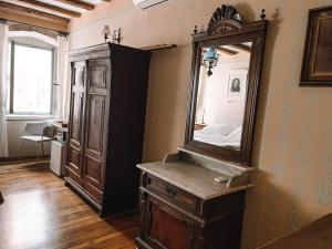 a bedroom with a large mirror and a wooden dresser at Hotel Casa Garzotto in Rovinj