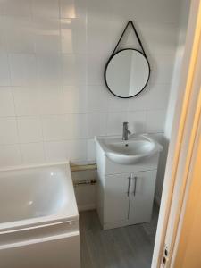 uma casa de banho com um lavatório e um espelho na parede em one bedroom flat near Vauxhall train station London em Londres