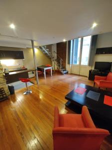 sala de estar amplia con sillas de color naranja y sofá en Hermoso Loft Centrico en Buenos Aires