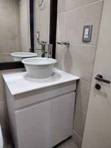 y baño con lavabo blanco y espejo. en Hermoso Loft Centrico en Buenos Aires