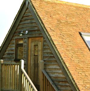 uma casa com uma porta de madeira e um alpendre em Rosebank B&B em Etchingham
