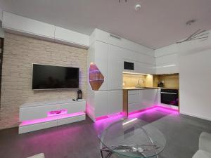 a kitchen with purple led lighting in a room at Sunset Apartament in Wrocław