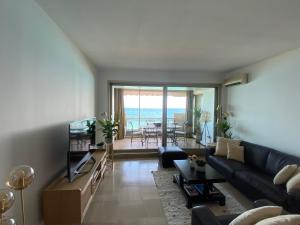uma sala de estar com um sofá e vista para o oceano em LE BAHIA em Nice