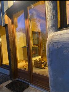 een open glazen deur van een huis met een raam bij Gîte atypique in Borrèze