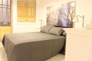 sypialnia z łóżkiem w białym pokoju w obiekcie Amazing Sevilla Apartamento w Sewilli