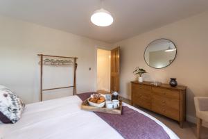 a bedroom with a bed with a bowl of fruit and a mirror at Two Ways in Tansley