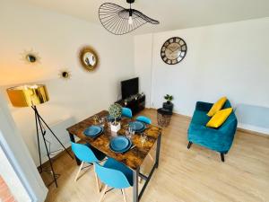 a dining room with a table and chairs and a clock at Appartement luxueux et cosy in Cergy