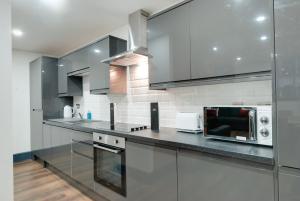 a kitchen with stainless steel cabinets and a microwave at Harrisons Aparthotel Liverpool in Liverpool