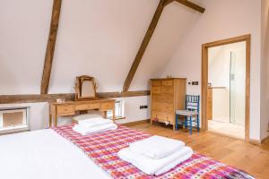1 dormitorio con 1 cama con tocador y espejo en Granary Barn Snape Air Manage Suffolk en Saxmundham
