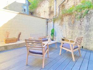 2 chaises et une table sur une terrasse dans l'établissement - Le Lys - Magnifique maisonnette avec terrasse, à Poitiers