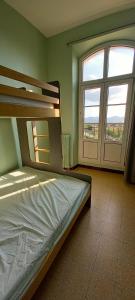 - une chambre avec un lit et une grande fenêtre dans l'établissement Auberge de Jeunesse HI Marseille Bois-Luzy, à Marseille