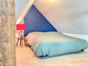 uma cama de dossel azul num quarto em - Le Lys - Magnifique maisonnette avec terrasse em Poitiers