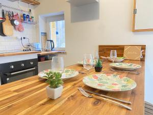 a kitchen with a wooden table with plates and glasses at - Le Lys - Magnifique maisonnette avec terrasse in Poitiers +11 photos