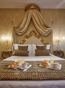 Cette chambre d'hôtel dispose d'un lit avec deux assiettes de nourriture. dans l'établissement Hotel Orsaria, à Venise