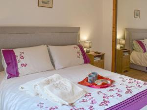 a bed with towels and a tray of food on it at Little Gem in Kirkcaldy