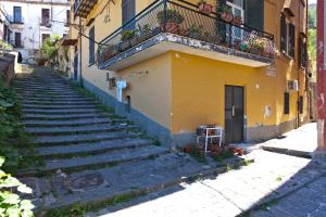 eine Gasse mit einer Treppe vor einem gelben Gebäude in der Unterkunft Casa Milì by Wonderful Italy in Neapel