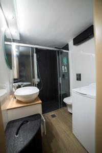 ein Bad mit einem Waschbecken und einer Dusche in der Unterkunft Luxurious apartment in the heart of town ! in Loutraki