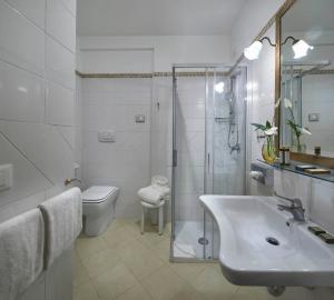La salle de bains est pourvue d'un lavabo, d'une douche et de toilettes. dans l'établissement Hotel Orsaria, à Venise