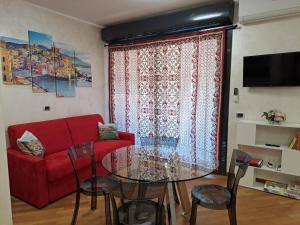 sala de estar con sofá rojo y mesa de cristal en La casa sul molo - Acquario, en Génova