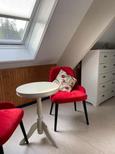 ブロクゼイルにあるB&B De Strandhoeveのテーブルと椅子2脚、窓が備わる客室です。