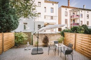 un patio con mesa, sillas y sombrilla en Sadebo Apartments Lübeck mit Terrasse oder Balkon en Lübeck