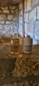 dos frascos sentados en un mostrador junto a una pared de ladrillo en Casa Cipampini, en Petralia Soprana