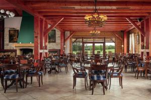 a dining room with tables and chairs and a fireplace at Golf & Spa Kunětická Hora in Dritec