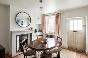 a dining room with a table and chairs and a mirror at Parva House (Holt) in Holt