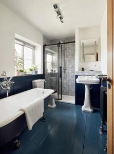 a bathroom with a tub and two sinks and a shower at Parva House (Holt) in Holt