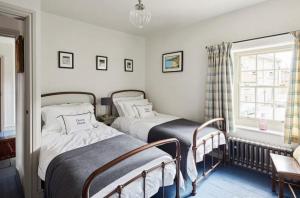 two twin beds in a room with a window at Parva House (Holt) in Holt