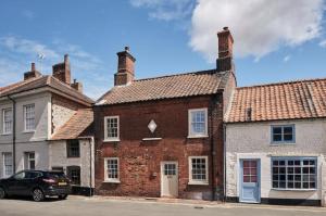 a brick building with a car parked in front of it at Parva House (Holt) in Holt