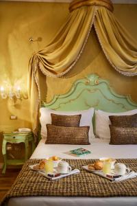 a hotel room with a bed with two plates of food on it at Hotel Orsaria in Venice