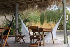 uma mesa e cadeiras sentadas sob uma rede de descanso em Mirante Morere em Morere