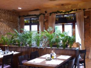 a restaurant with tables and chairs and plants at Pensione Ristorante Moretti in Nitra