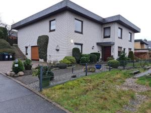 une maison avec une clôture devant elle dans l'établissement Schöne ruhige Eigentumswohnung mit Terrasse, à Flensbourg