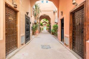 um beco numa cidade velha com portões e uma arcada em Riad Anir em Marrakech