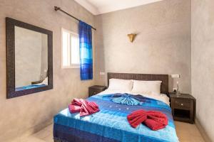 um quarto com uma cama com toalhas vermelhas em Riad Anir em Marraquexe