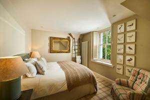1 dormitorio con cama, ventana y silla en Hazelbank, sleeps 10, on the shores of Loch Fyne, en Cairndow